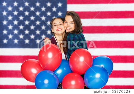 teenage girls with balloons over american flag 55576223
