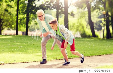 grandfather and grandson racing at summer park 55576454