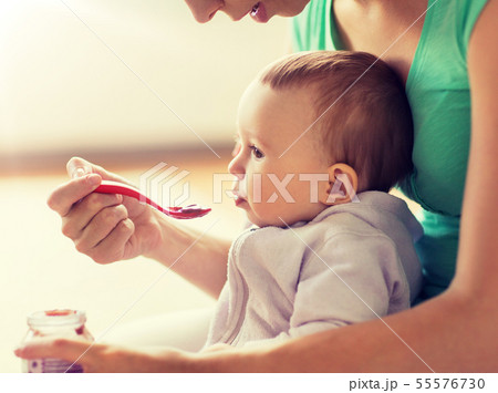 mother with spoon feeding little baby at home mother with spoon feeding little baby at home 55576730