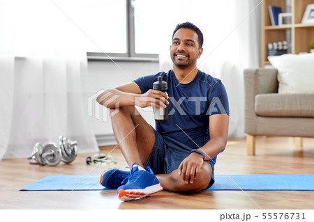 indian man drinking water after training at home 55576731