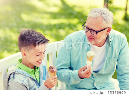 old man and boy eating ice cream at summer park 55576999