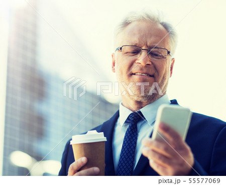 businessman with smartphone and coffee in city 55577069