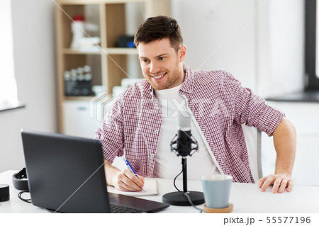 audio blogger with laptop, microphone and notebook 55577196