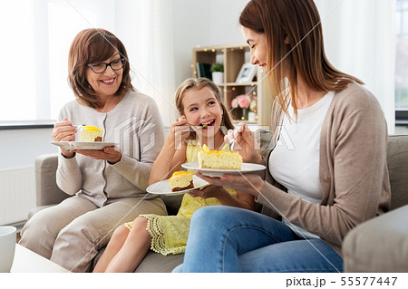 mother, daughter and grandmother eating cake mother, daughter and grandmother eating cake 55577447