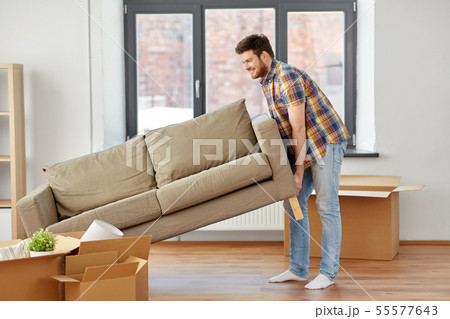 happy man moving sofa at new home 55577643