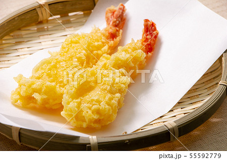 海老の天ぷら2本。(まっすぐに揚げられ、ざるに敷いた天ぷら敷き紙上に盛り付け。) 海老の天ぷら2本。(まっすぐに揚げられ、ざるに敷いた天ぷら敷き紙上に盛り付け。) 55592779