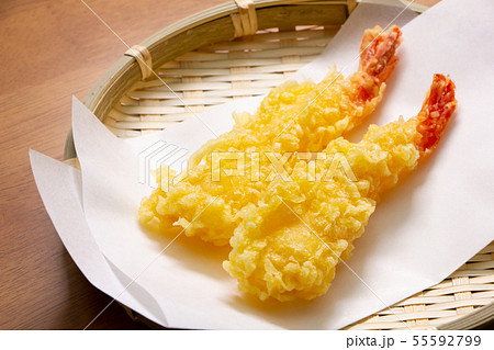 海老の天ぷら2本。(まっすぐに揚げられ、ざるに敷いた天ぷら敷き紙上に盛り付け。) 海老の天ぷら2本。(まっすぐに揚げられ、ざるに敷いた天ぷら敷き紙上に盛り付け。) 55592799