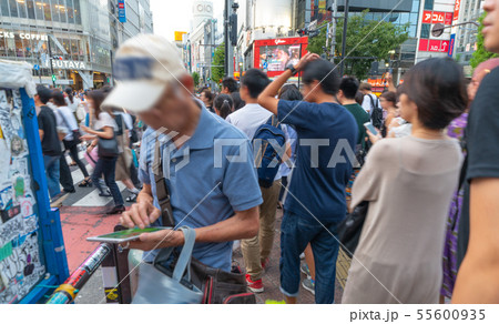 日本の東京都市景観 渋谷スクランブル交差点前でゲームを長時間する高齢者 日本の東京都市景観 渋谷スクランブル交差点前でゲームを長時間する高齢者 55600935