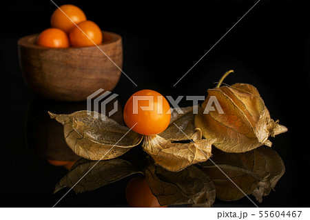 Fresh orange physalis isolated on black glass Fresh orange physalis isolated on black glass 55604467