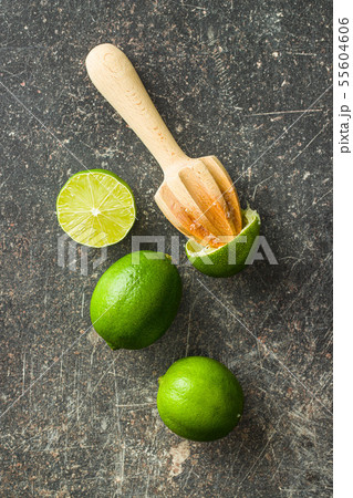 Wooden citrus squeezer and green lime. 55604606