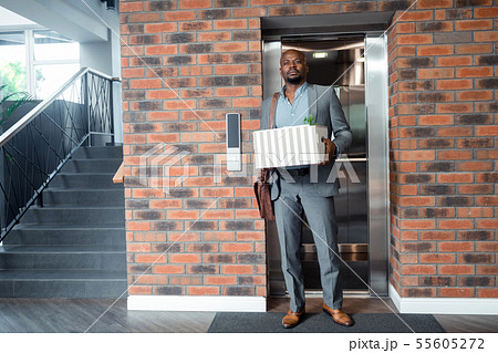 Worker wearing grey suit standing in elevator after been fired 55605272