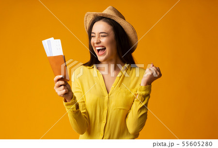 Gladful Woman Traveler Holding Tickets And Passport Over Yellow Background Gladful Woman Traveler Holding Tickets And Passport Over Yellow Background 55605280