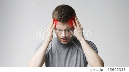 Young man suffering from headache after hard working day 55605353