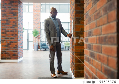 Young businessman wearing glasses standing near elevator 55605376