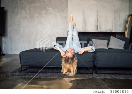 Woman enjoying on a couch with head upside down. 55605816