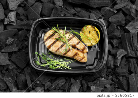 Tasty grilled fish with lemon and rosemary in to go box on coal Tasty grilled fish with lemon and rosemary in to go box on coal 55605817