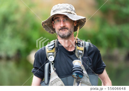 Portrait of mid adult fisherman on river, relaxing and fishing trouts. Portrait of mid adult fisherman on river, relaxing and fishing trouts. 55606648