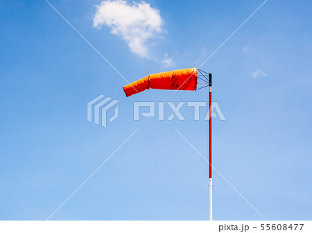 Windsock on pole against blue sky. Windsock on pole against blue sky. 55608477