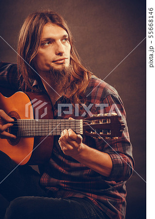 Man with beard is playing the guitar. 55668146