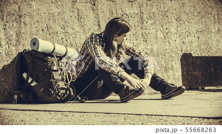 Man tourist backpacker sitting by grunge wall 55668263