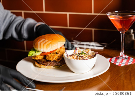 man in black gloves eating burger in the restaurant 55680861