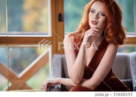 Happy woman enjoying the autumn air at open window 55688355