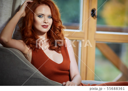 Happy woman enjoying the autumn air at open window Happy woman enjoying the autumn air at open window 55688361