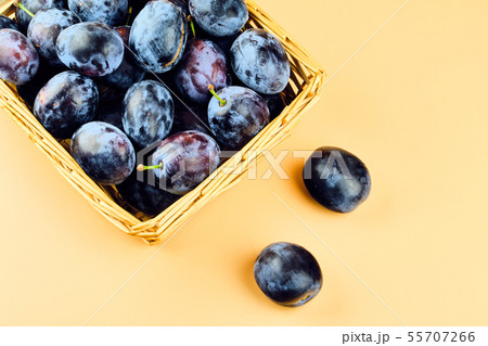 Plums in basket isolated on beige background Plums in basket isolated on beige background 55707266