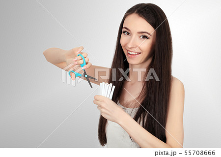 Stop smoking concept. Young woman cut cigarettes with scissors happy smiling. focus on hand Stop smoking concept. Young woman cut cigarettes with scissors happy smiling. focus on hand 55708666