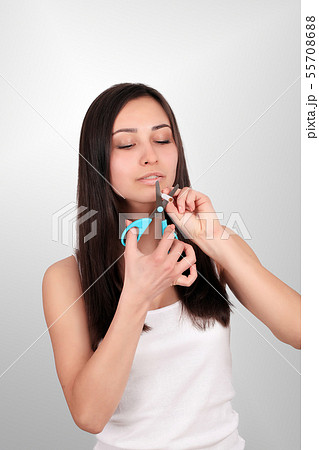Stop smoking concept. Young woman cut cigarettes with scissors happy smiling. focus on hand Stop smoking concept. Young woman cut cigarettes with scissors happy smiling. focus on hand 55708688