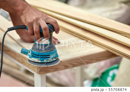 Grinder worker polishes a wooden board. Sanding boards Orbital eccentric machine. 55708874