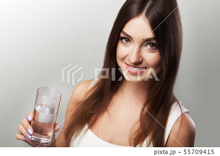 Drink water. Young girl drinking water from the glass. Daily water intake. Clean water. The concept Drink water. Young girl drinking water from the glass. Daily water intake. Clean water. The concept 55709415