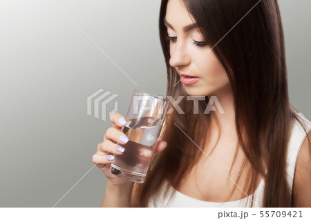 Drink water from the glass. A young healthy girl drinks water from the glass. Healing the body. The Drink water from the glass. A young healthy girl drinks water from the glass. Healing the body. The 55709421