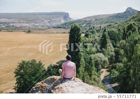 Hiker sitting on the top of the mountain. Hiker sitting on the top of the mountain. 55711771