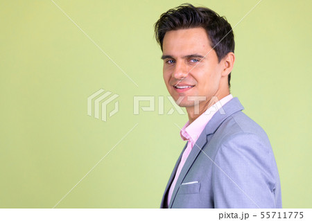 Closeup profile view of happy young handsome businessman looking at camera Closeup profile view of happy young handsome businessman looking at camera 55711775