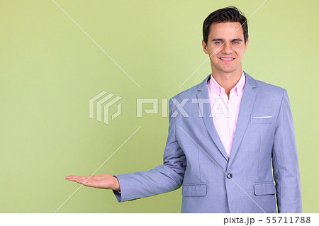 Portrait of happy young handsome businessman showing something Portrait of happy young handsome businessman showing something 55711788