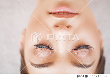 Woman Eye with Long Eyelashes. Beautiful Young Woman During Eyelash Extension 55713290