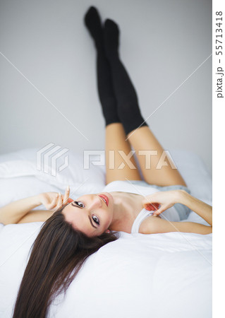 Relaxing On Bed During Weekend. Beautiful Woman Relaxing on a Bed and Looking Happy Relaxing On Bed During Weekend. Beautiful Woman Relaxing on a Bed and Looking Happy 55713418