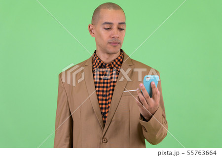 Handsome bald multi ethnic businessman using phone Handsome bald multi ethnic businessman using phone 55763664