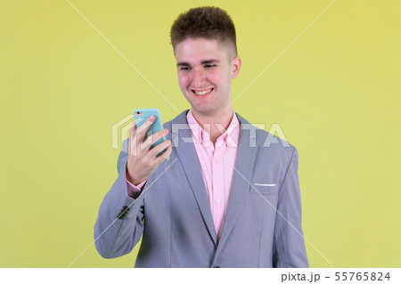 Portrait of happy young businessman using phone 55765824