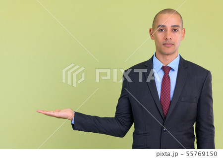 Handsome bald multi ethnic businessman showing something 55769150