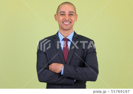 Happy bald multi ethnic businessman smiling with arms crossed Happy bald multi ethnic businessman smiling with arms crossed 55769197