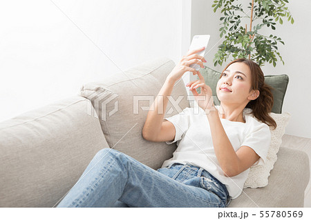 ソファーでスマホを使う女性 ソファーでスマホを使う女性 55780569