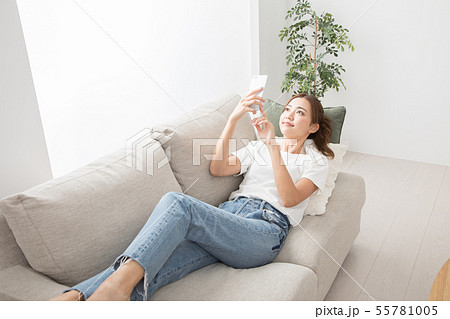 ソファーでスマホを使う女性 ソファーでスマホを使う女性 55781005