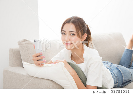 ソファーでスマホを使う女性 55781011
