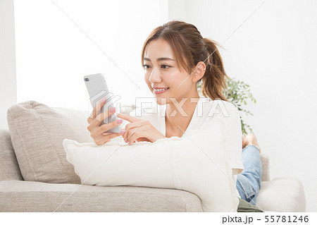 ソファーでスマホを使う女性 ソファーでスマホを使う女性 55781246