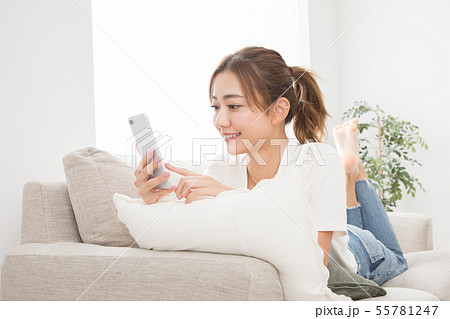 ソファーでスマホを使う女性 ソファーでスマホを使う女性 55781247