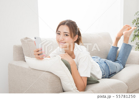 ソファーでスマホを使う女性 ソファーでスマホを使う女性 55781250