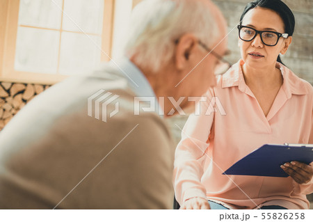 Dark-haired nurse touching her patient with one hand 55826258