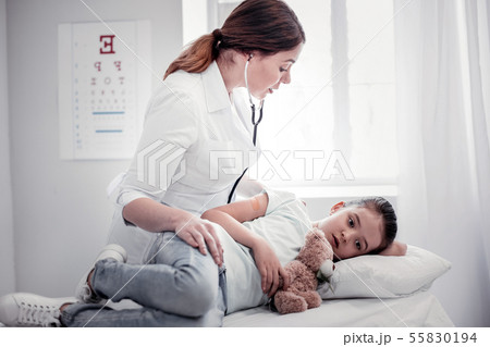 Sad ill girl lying on the medical bed Sad ill girl lying on the medical bed 55830194